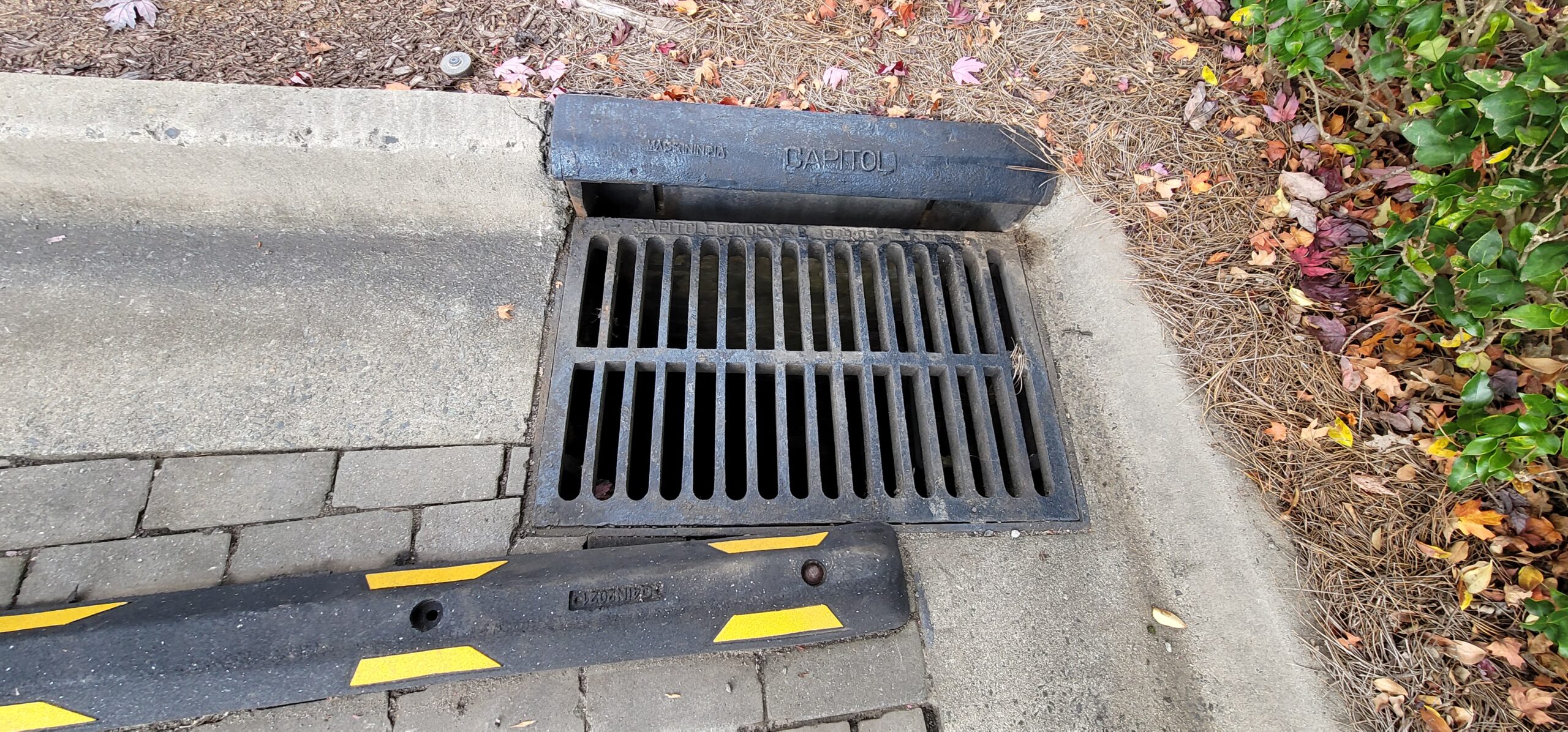 Stormwater catch basin with inlet, frame, and grate capturing roadway runoff