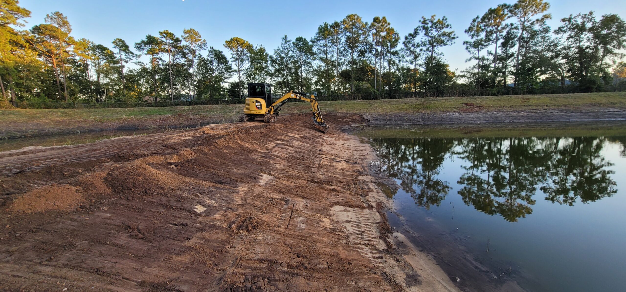 Stormwater pond shoreline restoration with riprap installation for erosion control and bank stabilization