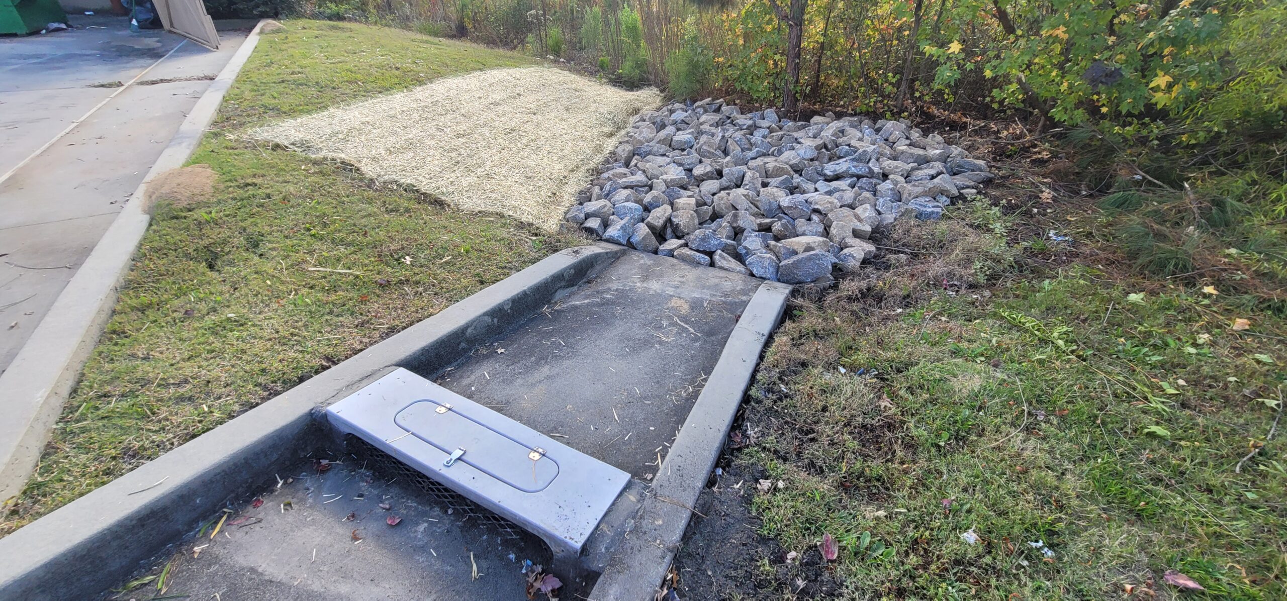 Stormwater inlet and outlet energy dissipator repair with restored riprap apron to prevent erosion and scour.