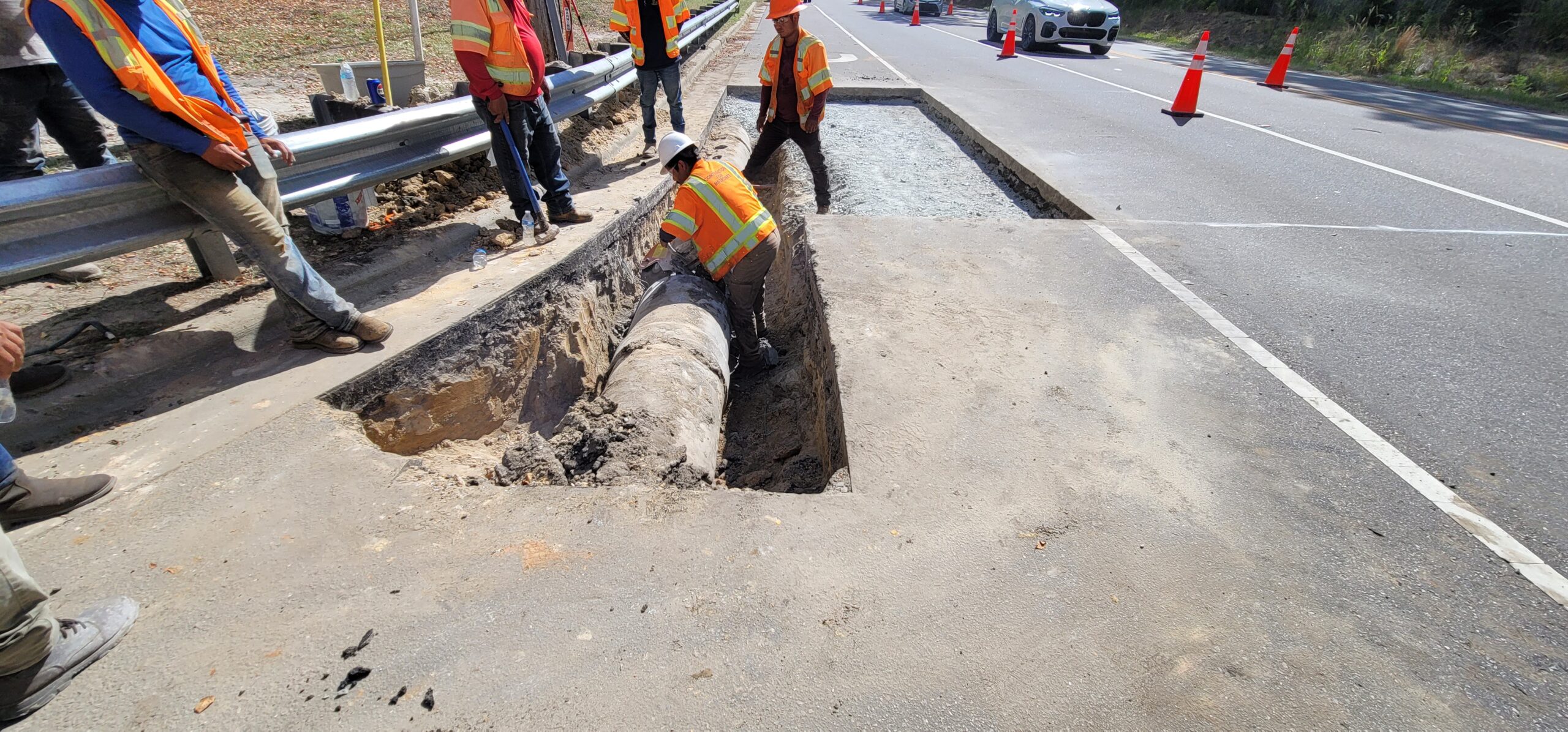 Workers repairing a stormwater pipe to restore proper drainage
