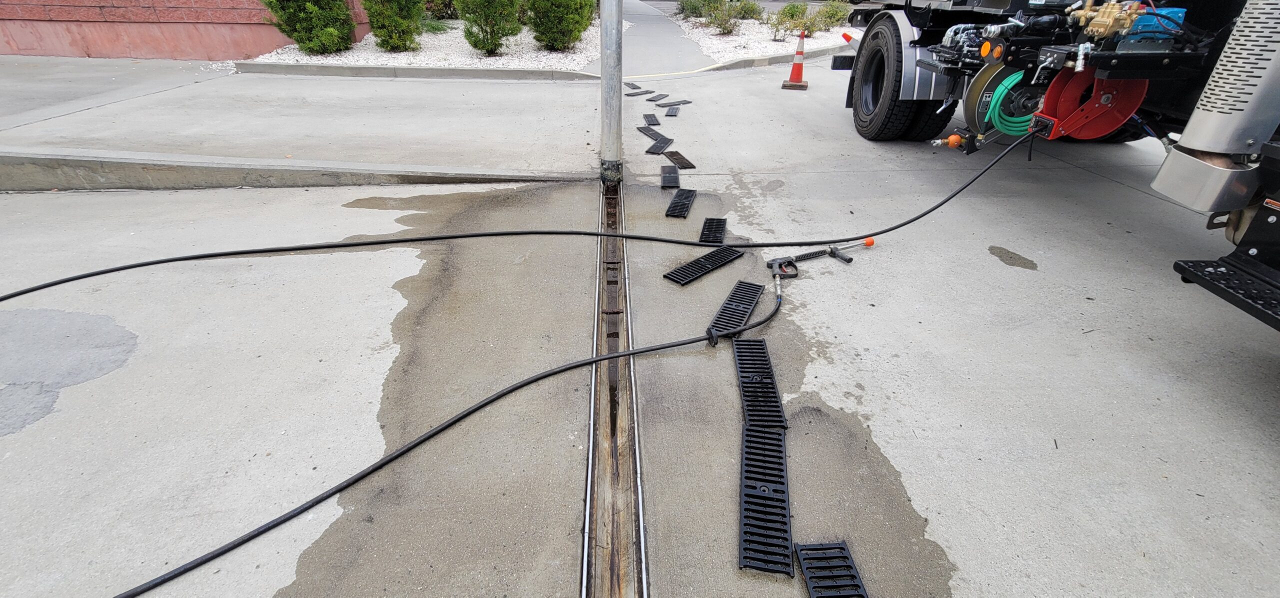 Vactor truck cleaning a trench drain to remove debris and restore proper stormwater flow.