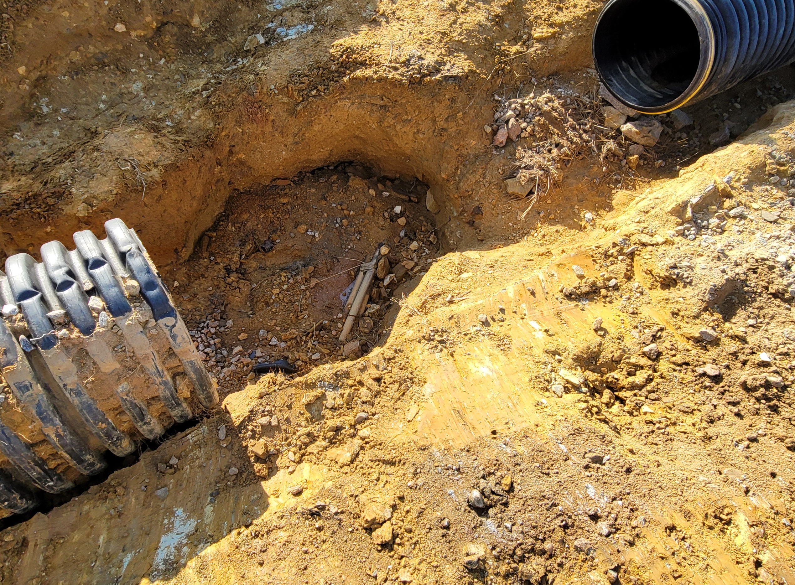 Vacuum hydro excavation removing soil around storm drain structure to prevent utility damage